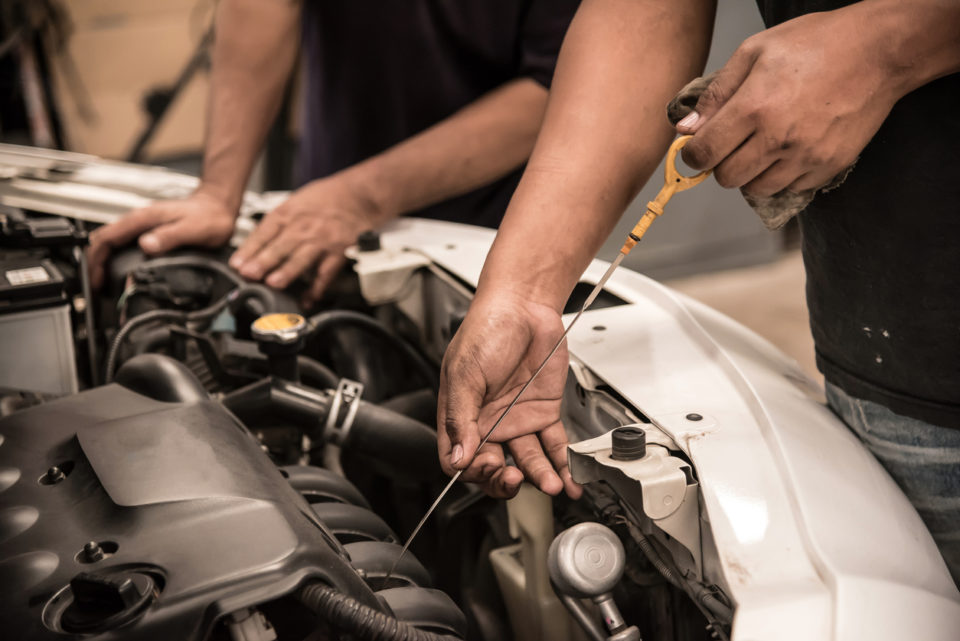 Mechanic checking level of new engine oil .