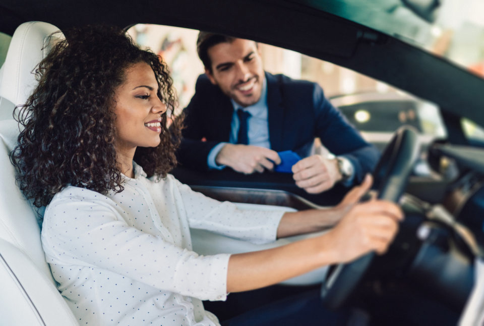 woman in the showroom enjoying luxury car