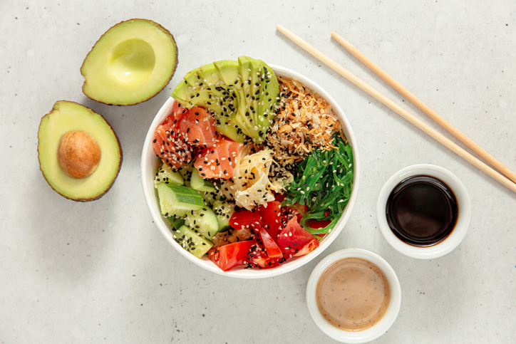 Hawaiian salmon and vegan poke bowls with salmon, avocado, cucumber, tomato and seaweed Top view, overhead, flat lay.