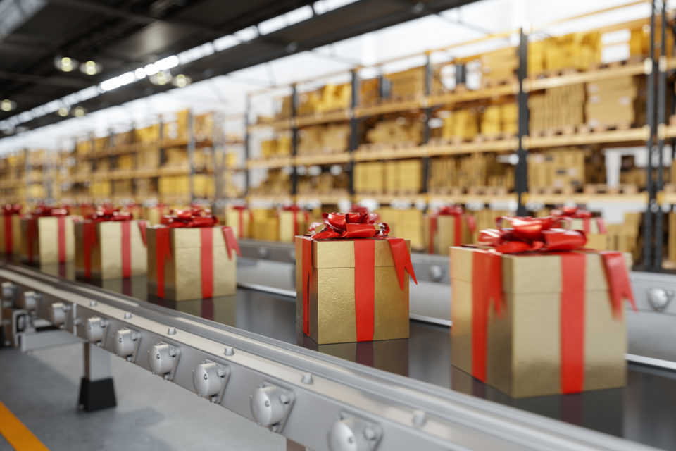 Gift Boxes Moving On Conveyor Belt With Blurred Warehouse Background