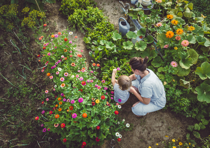 Tips To Grow Your Garden This Season. Woman With Son in a Home Grown Garden