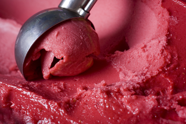 Delicious raspberry sorbet being scooped out.